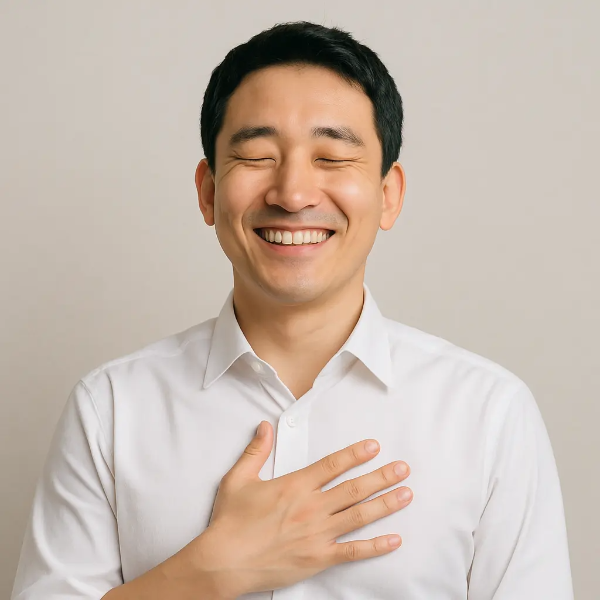 눈을 감고 가슴에 손을 얹은 채 미소 짓는 한국인 남성의 텍스트 없는 인물 이미지