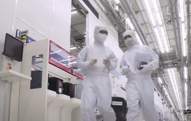 반도체 제조 공장에서 직원 두명이 걸어가는 모습