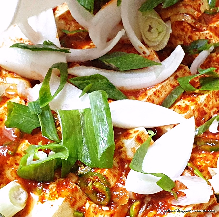 두부조림에 들어갈 양념장을 얹은 두부 위에 준비된 대파와 양파를 고루 올린 사진