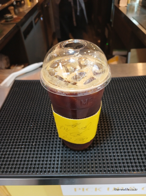 아침 공복에 마시는 아이스 아메리카노 실사 사진, 빈속에 커피를 마실 때 발생할 수 있는 위장 부담을 상징적으로 보여줌