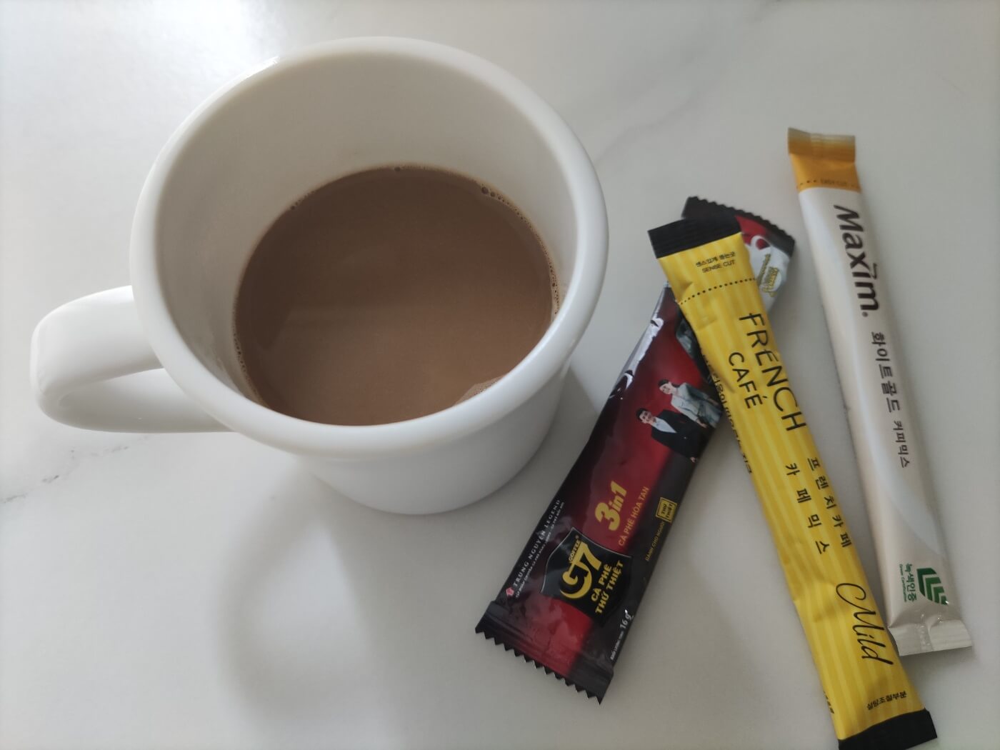 믹스커피 스틱 여러 개가 놓인 옆에 믹스커피가 담긴 하얀 컵. 믹스커피와 혈당 관리의 중요성을 설명하는 이미지.