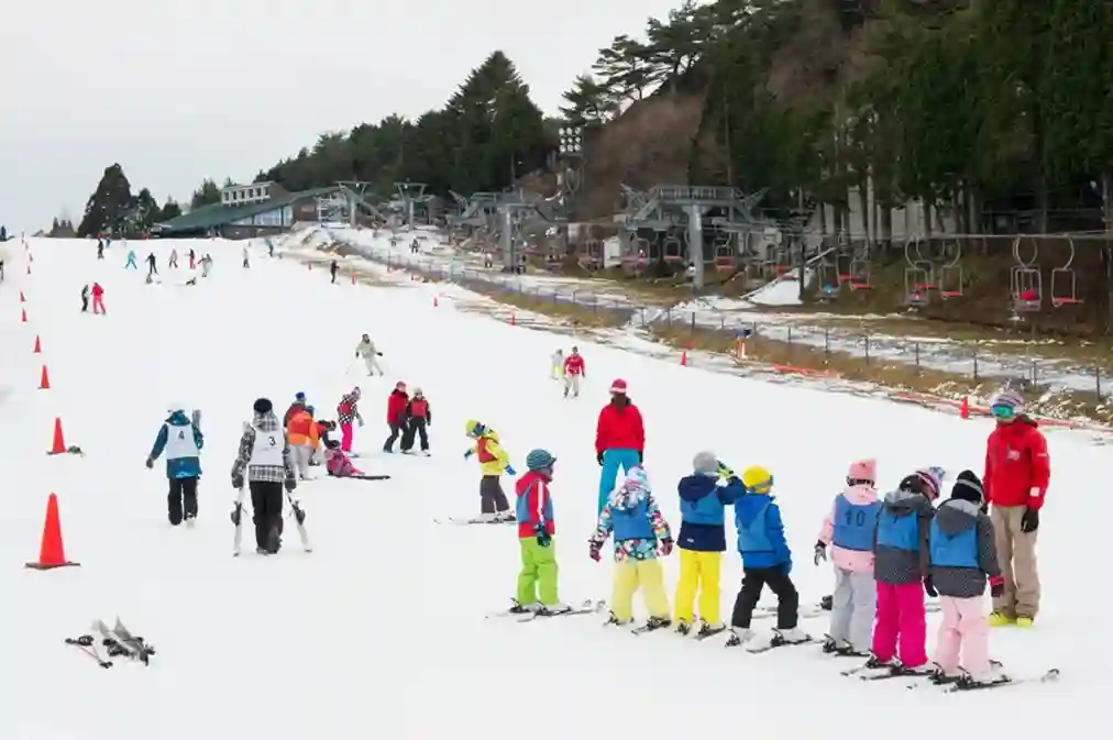 롯코산 스노우파크에서 스키 강습과 눈놀이를 즐기는 초보자와 가족 여행객