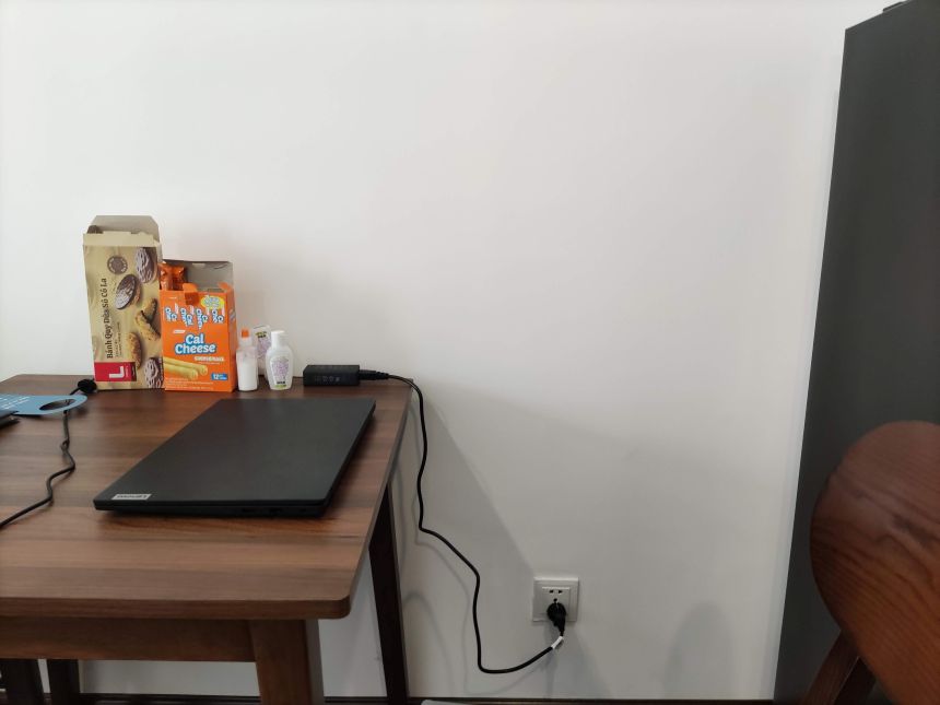 다낭 젠 로터스 호텔 객실 식탁에서 노트북 작업 중인 모습과 벽면 콘센트 위치