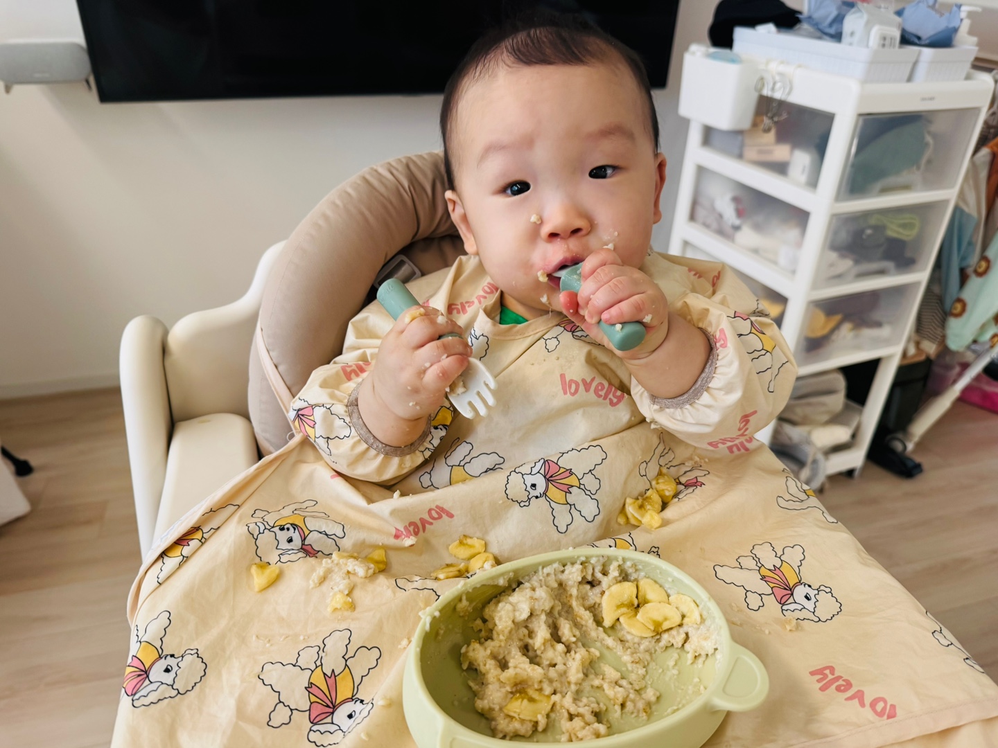 오트밀포리지를 떠먹으며 포크와 숟가락을 양손에 든 채 집중한 찬솔이의 아침 식사 모습