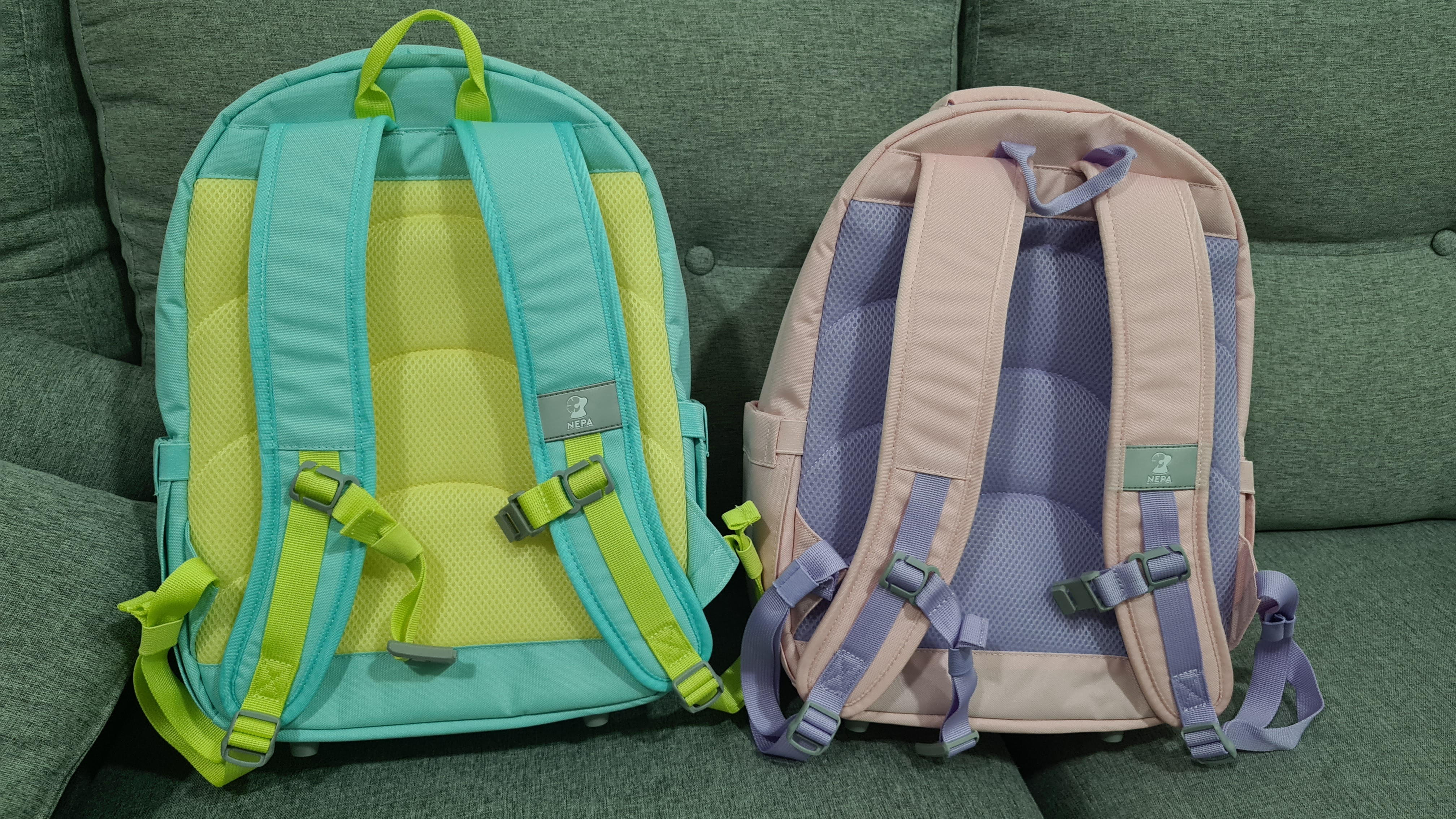 소파위에서 찍은 민트,핑크 색상의 네파 키즈 가방 후면부