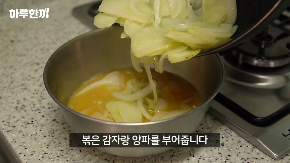 볶은 감자와 양파를 달걀물에 붓는 장면