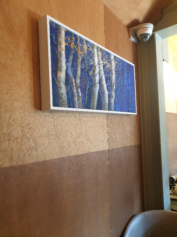 나부 벽면에 나무가 그려진 액자가 걸려있다.