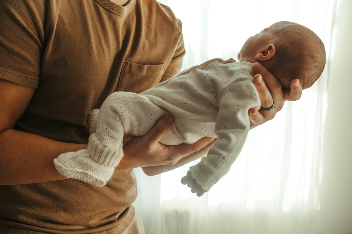Father holding his newborn baby gently