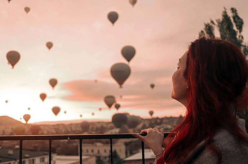 노을진-하늘에-떠있는-많은-열기구를-바라보는-모습