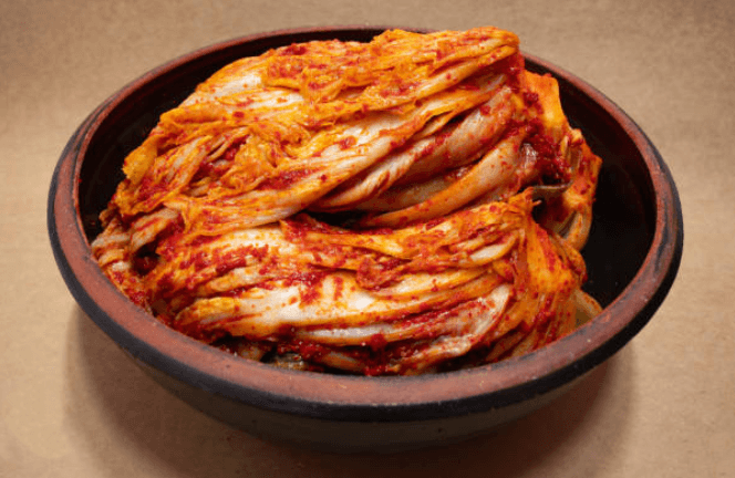 완성된 김치가 그릇에 담긴 이미지로 절임배추로 만든 김치의 색감과 식감을 시각적으로 표현한 사진입니다.