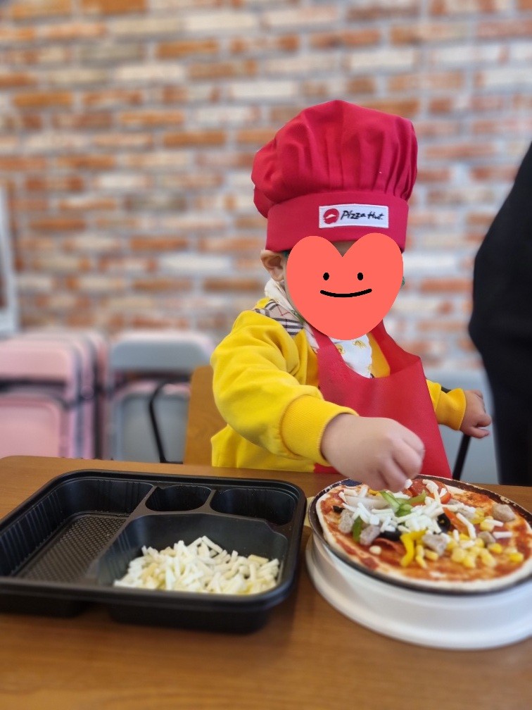 피자에 토핑을 올리는 아이
