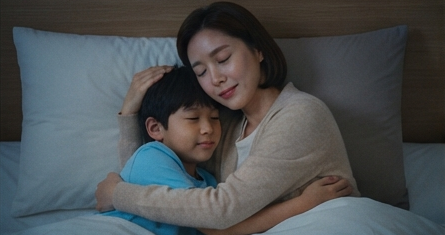잠자리에서 아들을 안아주며 대화하는 모습