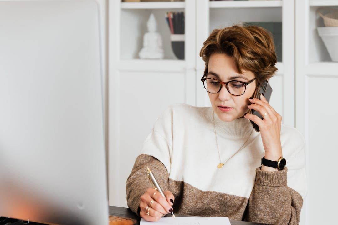 유심 재설정 정보 정리하며 통화 중인 직장인 여성