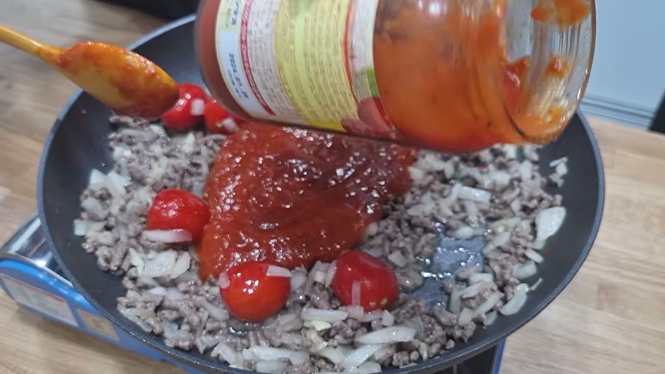 팬에 토마토 스파게티소스를 붓는 장면