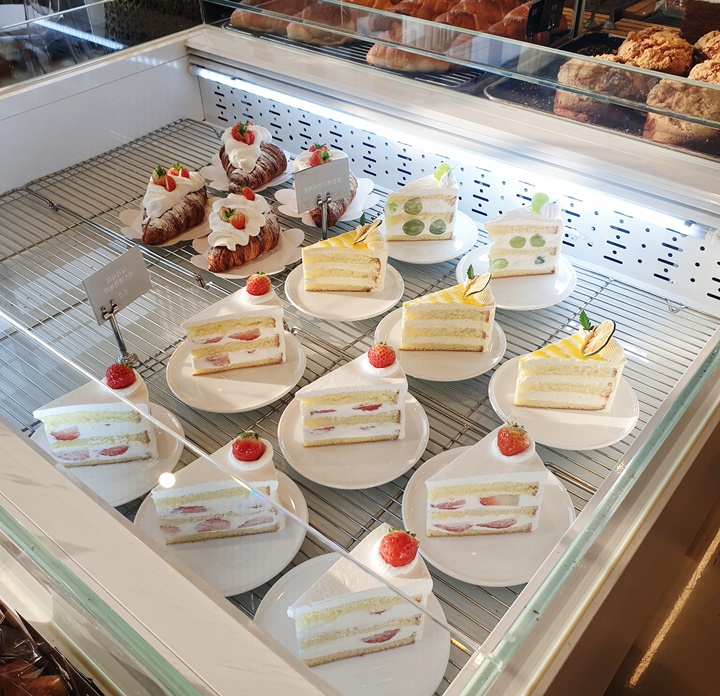 숲속의제빵소에서-판매되는-조각케이크들과-크림크로와상이-진열장에-놓여져있다