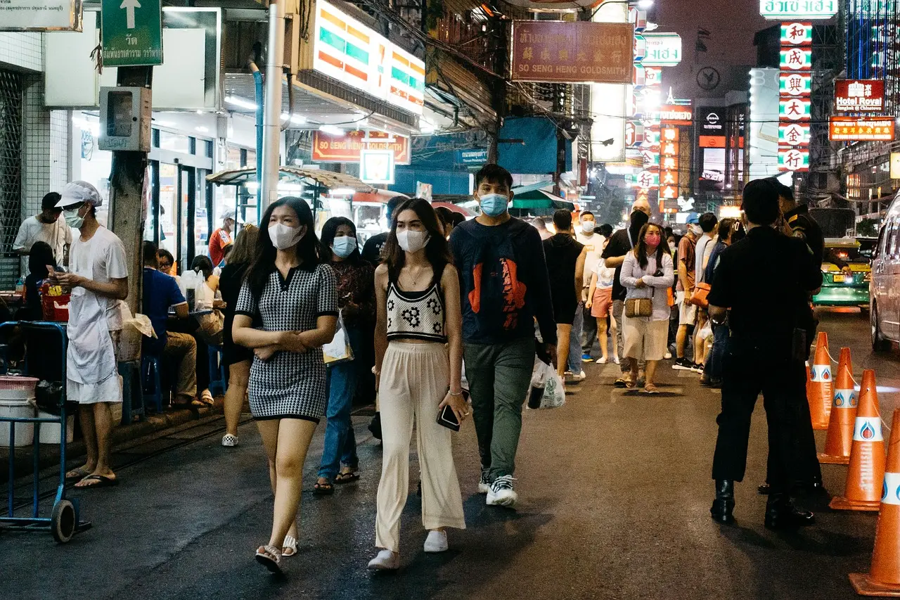 어두운 저녁 불이 켜진 시장을 돌아다니는 사람들