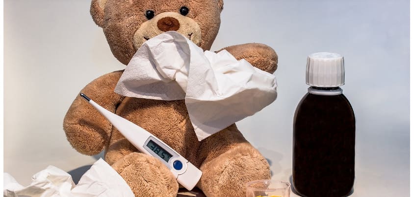 체온계와 감기약 및 화장지로 코를 푸는 곰인형