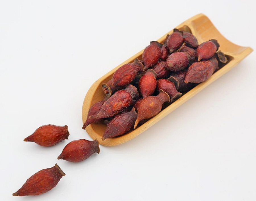 야생에서 채취를 한 금앵자 열매를 잘 세척한 후에 손질을 한 것을 하얀 바닥과 그 위에 대나무로 만든 길쭉한 받침대에 수북하게 쌓아두고 찍은 사진