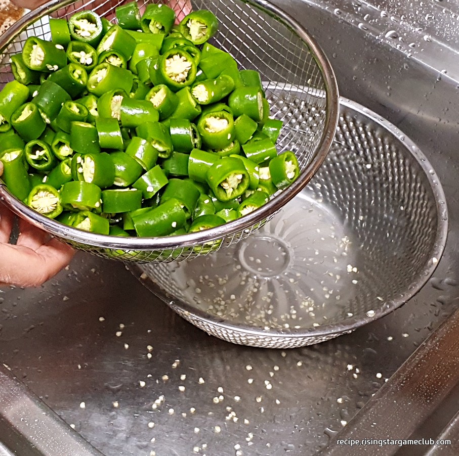풋고추 된장무침에 들어갈 채반에 담긴 풋고추를 털어서 씨를 제거하는 사진