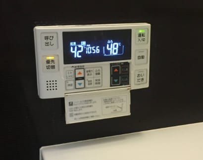 일본 욕조 리모컨이 벽에 붙여져 있는 사진 작은 화면에 온도가 나와있다.