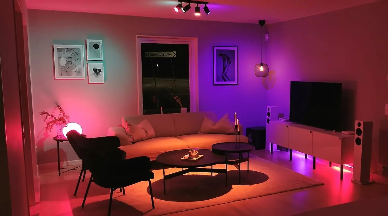 스마트 조명이 설치된 현대적인 거실 인테리어, 다양한 색상 조명으로 분위기를 조성하고 있는 모습