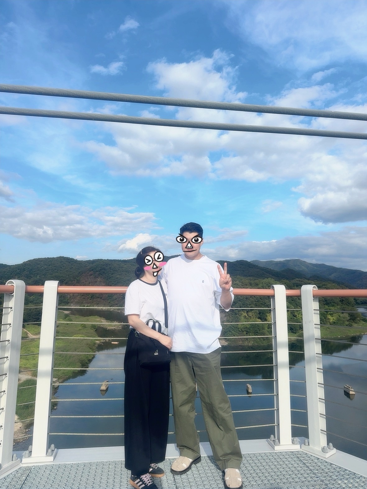 파란 하늘이 펼쳐진 연천 베개용암 출렁다리에서 강과 산 풍경을 배경으로 찍은 가족 여행사진