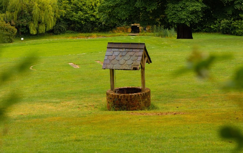 a well with small canopy in a wide lawn area