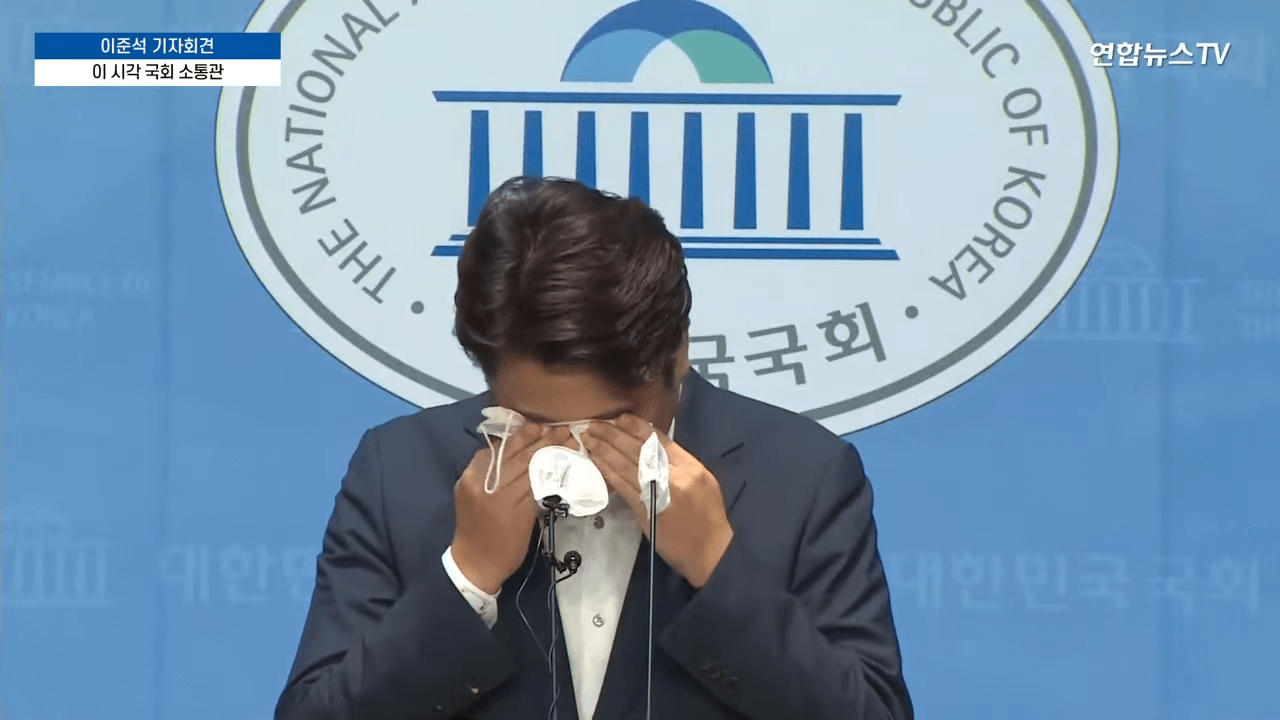 이준석 전 국민의힘 당대표가 법원에 가처분 신청 후 기자회견을 하다가 눈물이 쏟아져 하얀 마스크로 닦고 있다.
