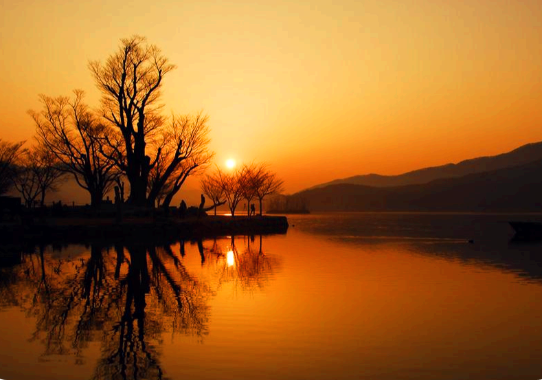 겨울 새벽 강 안개 사이로 떠오르는 해의 모습