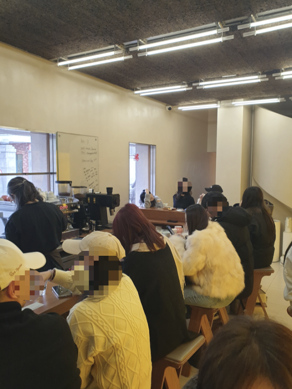 바리스타 앞 바 테이블에 앉아 있는 사람들