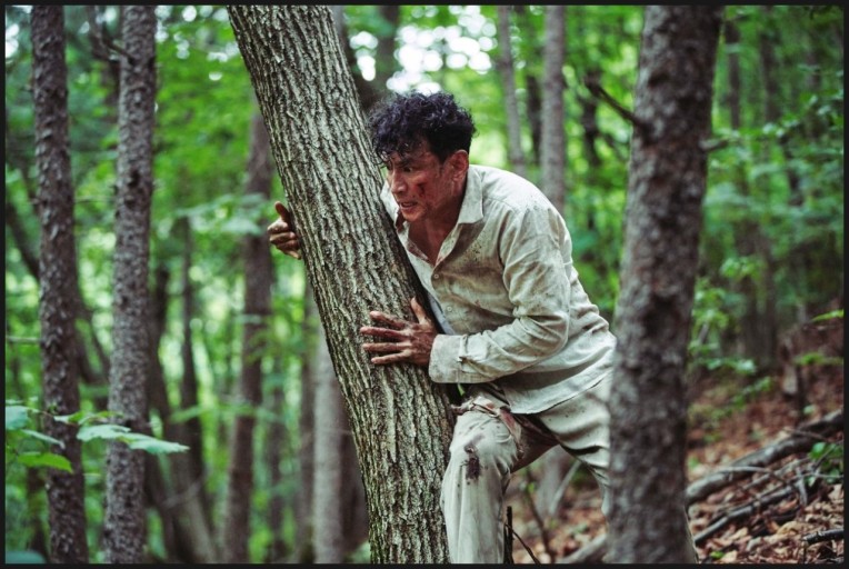 숲속으로 도망치고 있는 황정민의 모습