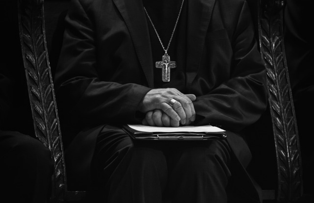 성직자의 두손을 공손히 모아 앉은 모습