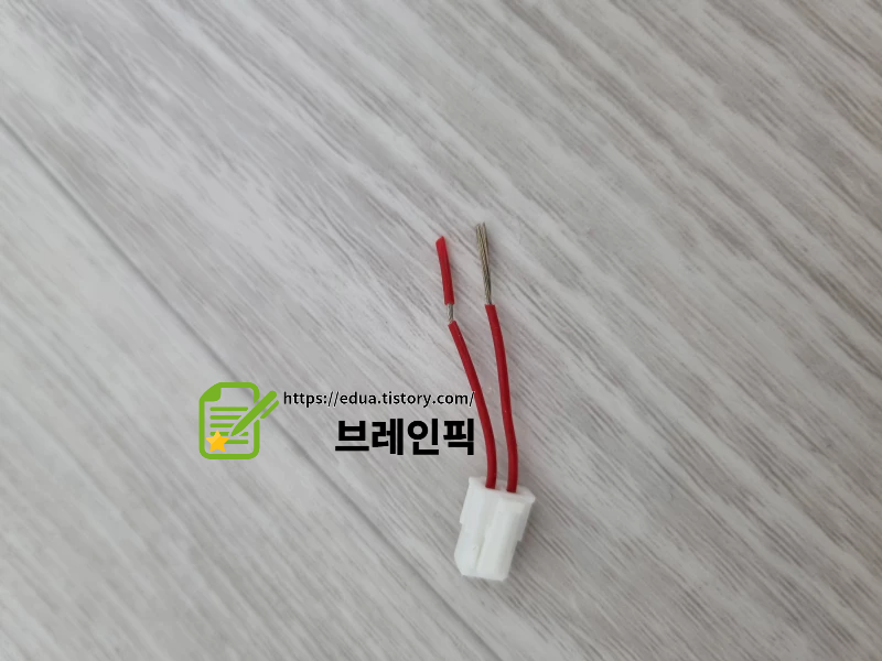 커넥터의 빨간 선전 부분을 잘라 피복을 벗기고 있다.