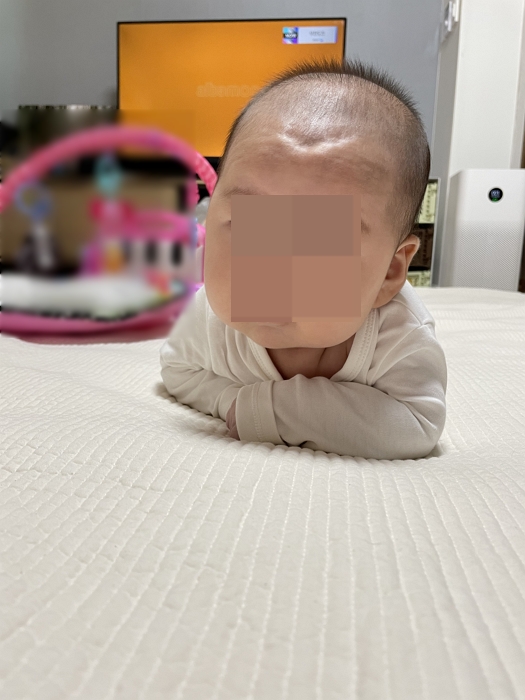 생후 3개월 아기가 엎드려 목을 들고 터미타임을 하는 모습