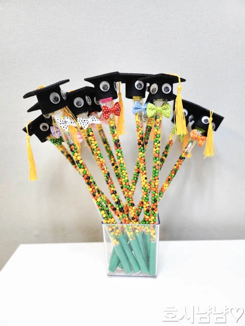 초등 졸업식 단체 선물 가위바위보 졸업 인형 여러 개를 꽃다발처럼 모아놓은 모습