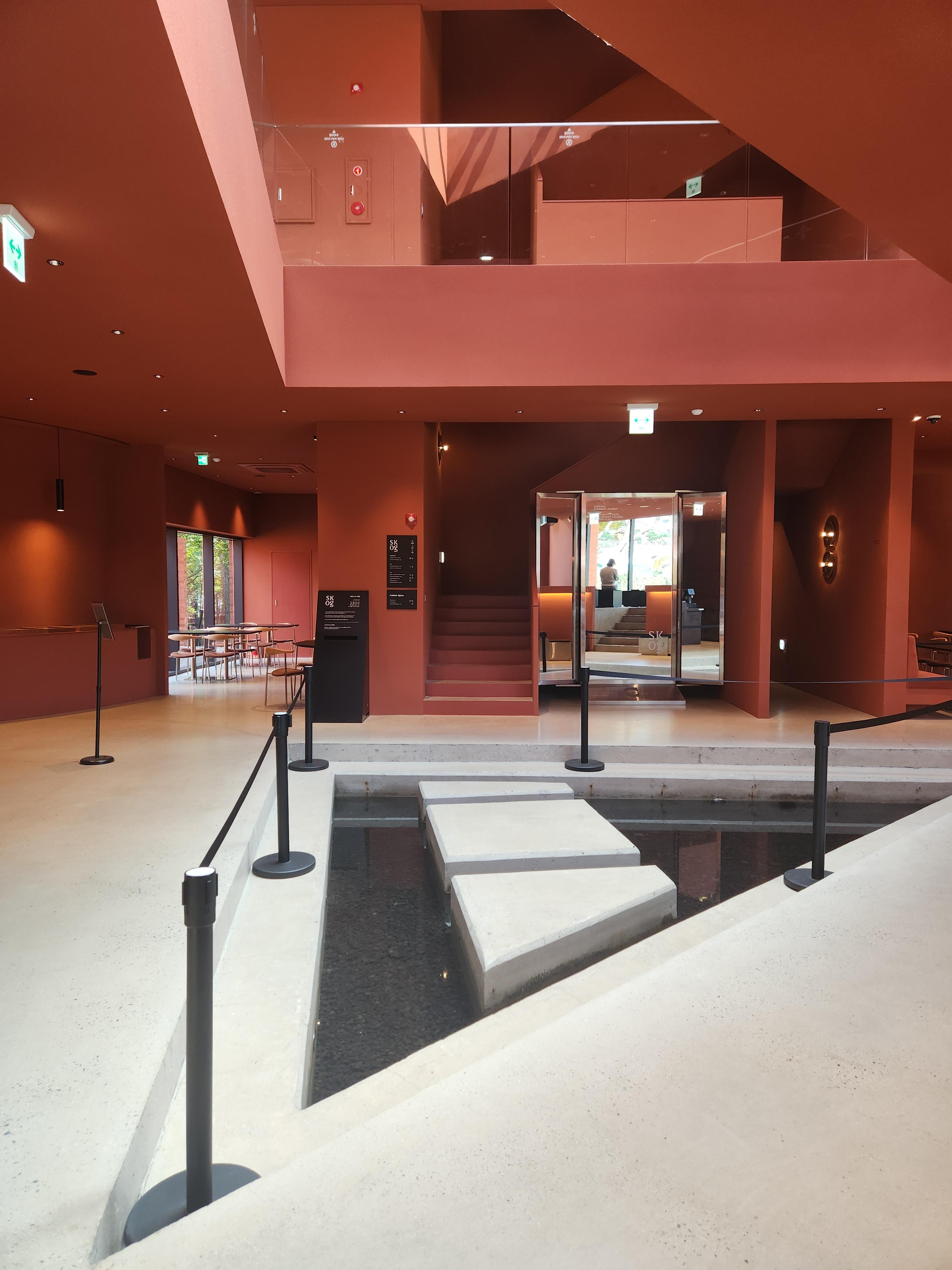 까페내부-붉은 톤의 벽면-중앙은 2층까지 뻥뚫린구조-해가 잘 들어 밝은 분위기