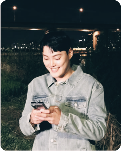 트로트 가수 김경민이 웃는 얼굴로 휴대폰을 들여다 본다