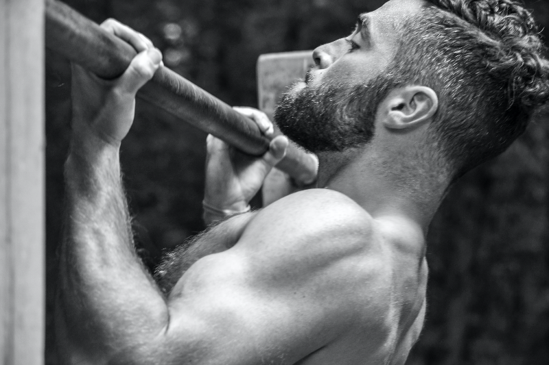 상의를-벗은-근육질-남성이-풀업-동작을-하고-있다