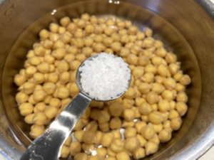 냄비에 불린 병아리콩&amp;#44; 물&amp;#44; 소금 담기