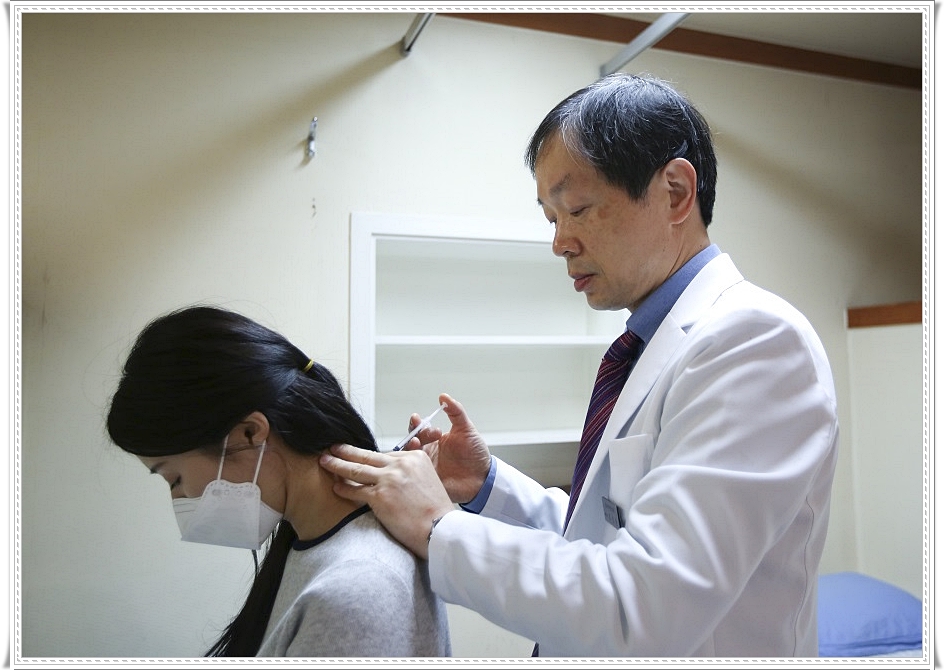 환자의 목 쪽에 약침을 놓고 있는 한의사의 모습