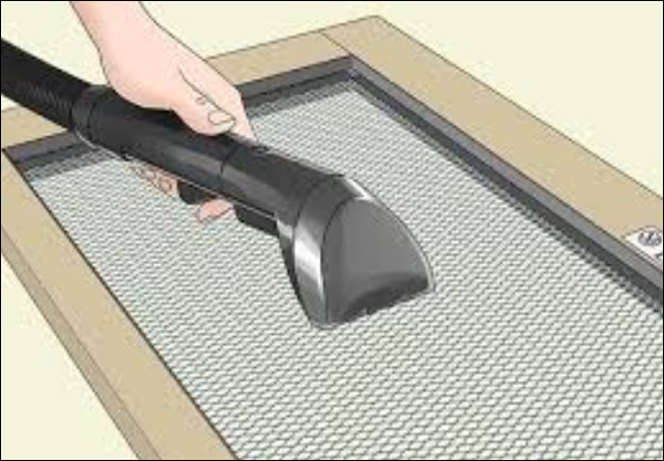 청소기로 방충망을 닦는 모습