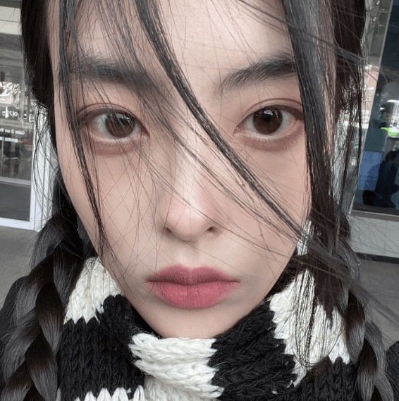 배우-배강희가-검정-하양-배색의-목도리를-착용하고-사진을-찍는-장면