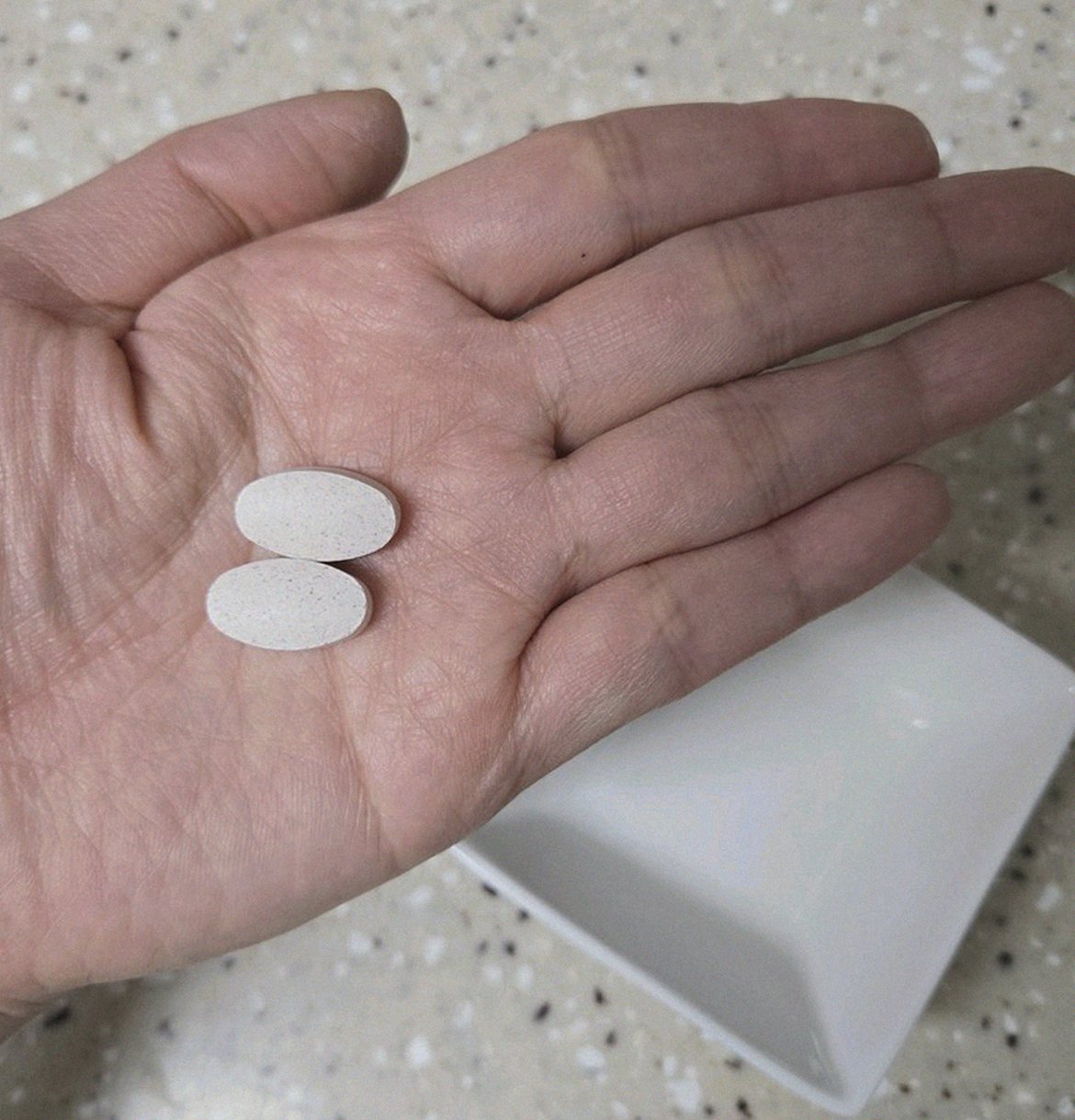 Korean Asian man in late 40s taking supplement after dinner