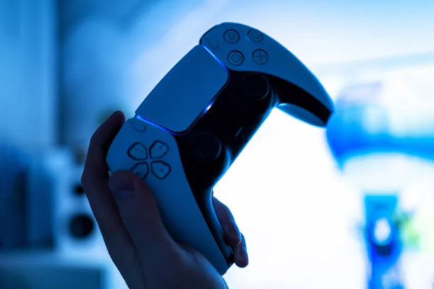 한 사람이 PS5 컨트롤러를 들고 있습니다.