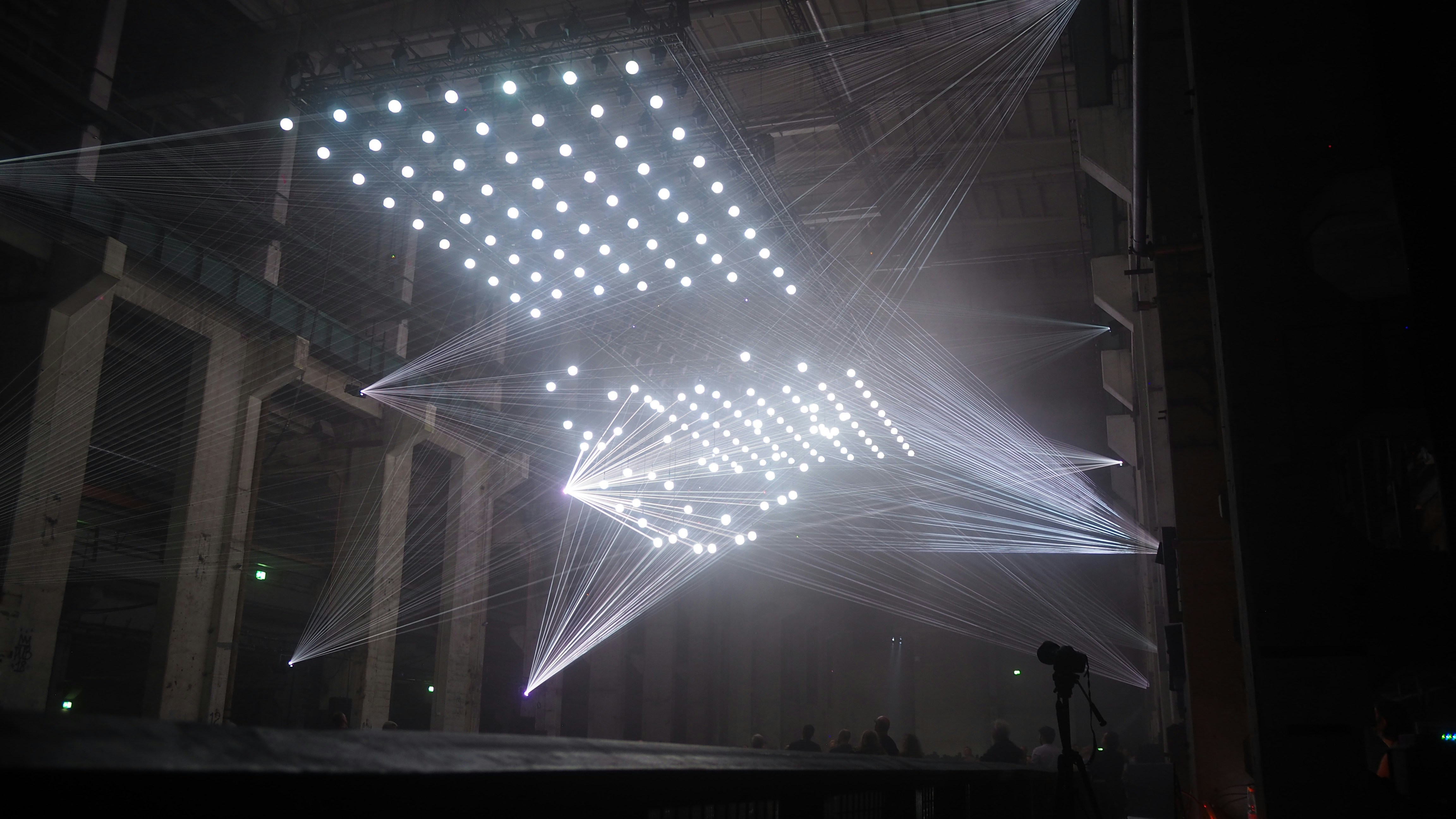 스포트라이트가 교차하는 대형 무대의 중앙, 마이크 스탠드와 조명 빔 관련 사진