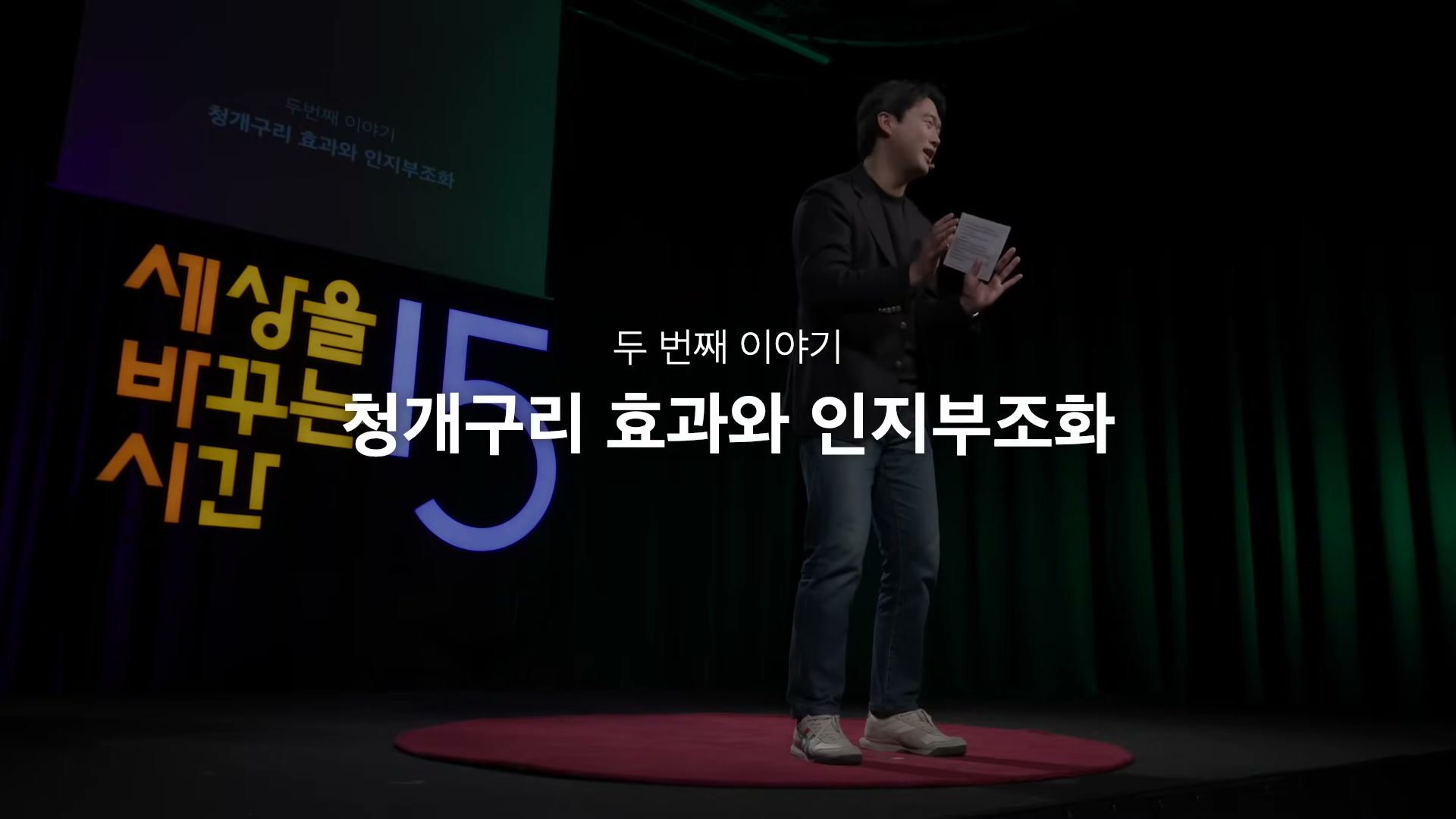 세바시 무대 위 빨간 카펫에 서서 카드를 들고 강연하는 류재언 변호사 &mdash; 배경에 '두 번째 이야기: 청개구리 효과와 인지부조화' 자막