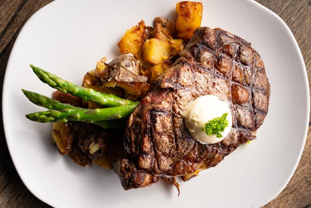 세도나 Open Range Grill에서 제공하는 Cowboy 스테이크와 아스파라거스, 감자 요리