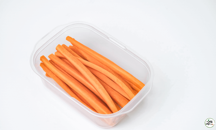 투명한-플라스틱통에-세로로-길게-잘린-당근이-담겨져있다