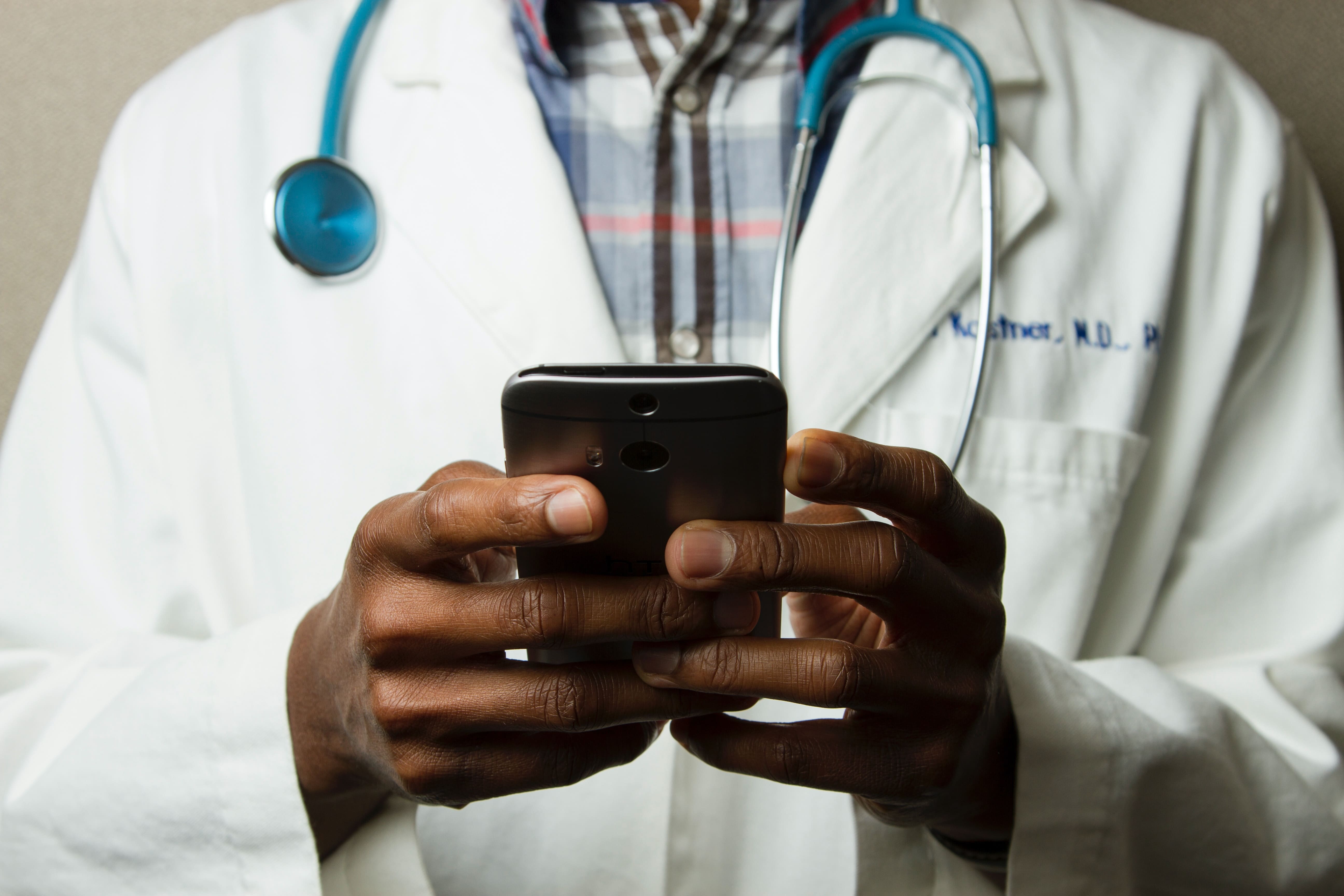 Doctor is touching mobile phone