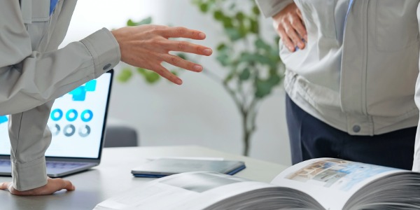 설계 도면을 보며 회의하는 두 명의 엔지니어 또는 건축가